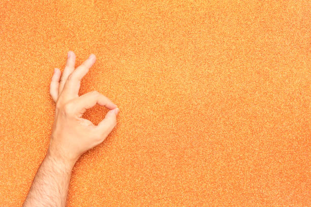 istock man arm with okay gesture in his left hand on glitter orange background 1416712964