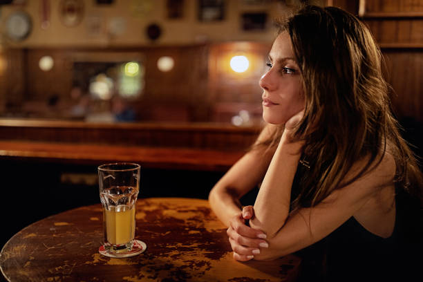 mujer deprimida está bebiendo cerveza en un bar - alcoholism drunk addiction drinking fotografías e imágenes de stock