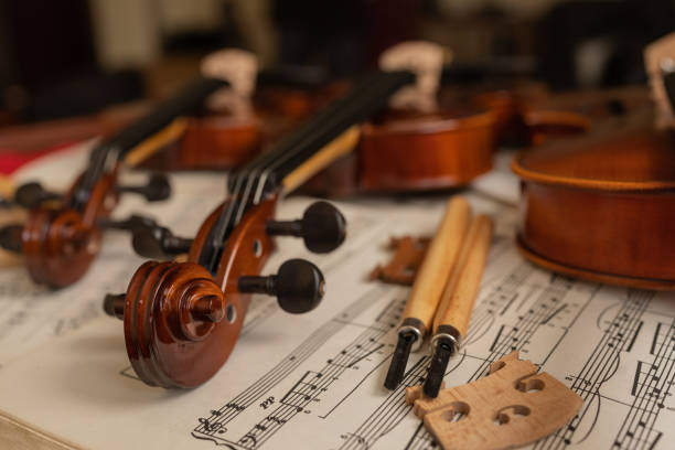 violines encima de partituras en un taller de reparación - musical instrument violin sheet music music fotografías e imágenes de stock