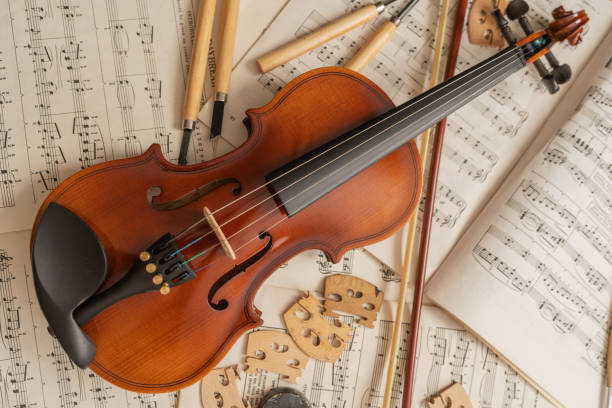 istock Violin on the top of music sheets in a workshop with tools and pieces 1416713973