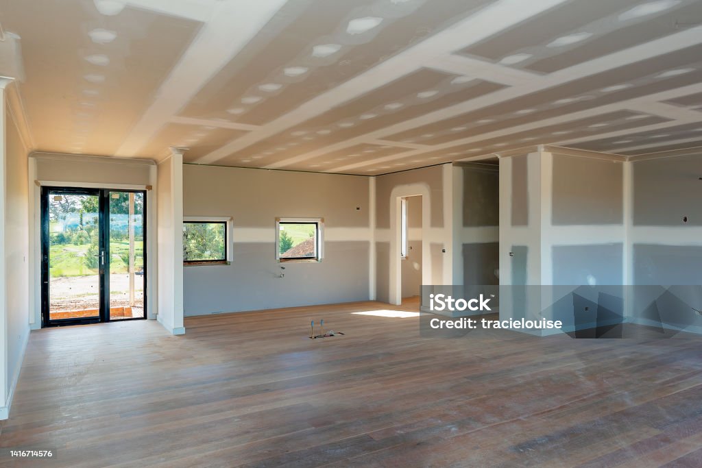 Residential house being built Residential home interior with plasterboard and newly laid timber flooring Drywall Stock Photo
