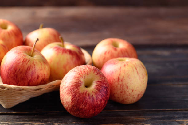 istock Red apple fruit in basket on wooden background 1416715376