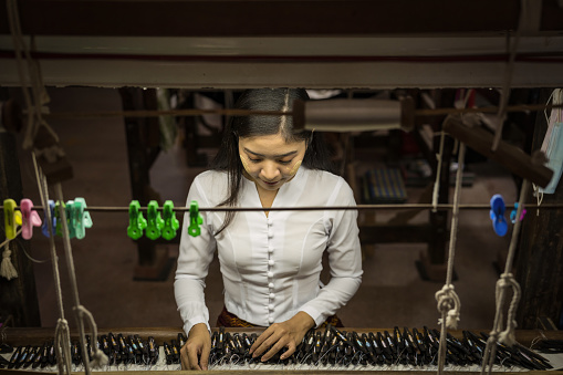 local Amarapura woman weaving hand-made tradional myanmar fabric at weaving factoryin Mandalay Myanmar