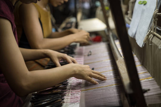 hände der lokalen amarapura-frau, die in der weberei handgefertigte traditionelle myanmar-stoffe weben - fashion industry textile man made material green stock-fotos und bilder