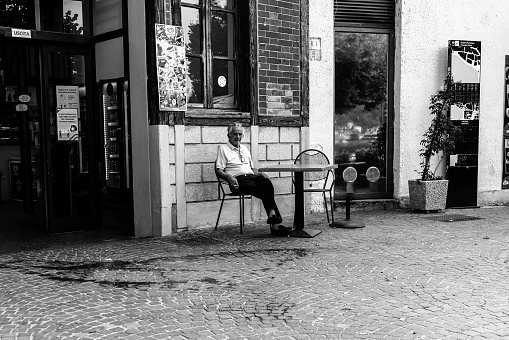 Lake Como, Italy - July 4, 2022: A man taking a rest on a patio at Lake Como, Italy