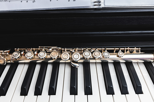 Close up of transverse flute on the keys of a piano