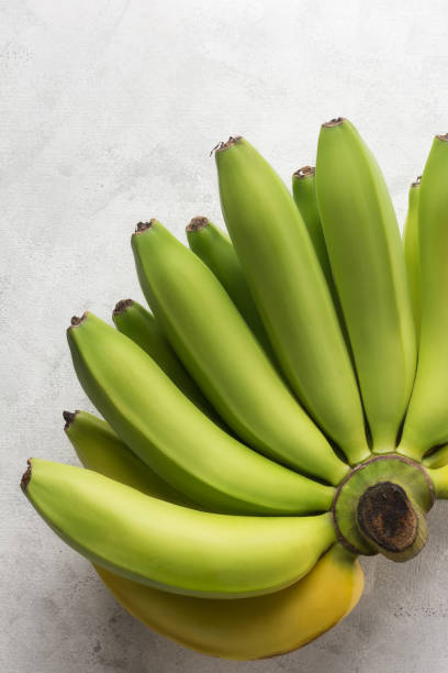 comb of fresh ripening banana on a white surface