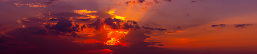 Panorama Dark cloud sunset.Colorful sunrise with dark Clouds sky.Sun hiding behind a cloud on the day sky.