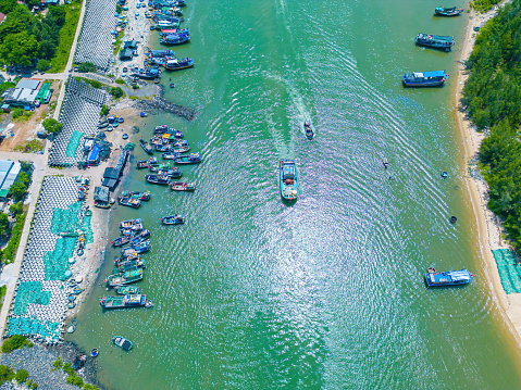 Beautiful blue skyline panoramic in Loc An Canal. Scenery landscape of fishing port with tsunami protection concrete blocks. Cityscape and boats in the sea. Loc An village near Vung Tau City.