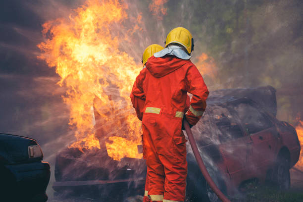 Firefighter fighting with flame using fire hose chemical water foam spray engine. Fireman wear hard hat, body safe suit uniform for protection. Rescue training in fire fighting extinguisher bomberos luchando con llama utilizando manguera de fuego motor de pulverización de espuma de agua química. bombero usar casco, cuerpo seguro traje uniforme para la protección. entrenamiento de rescate en extintor de lucha contra incendios