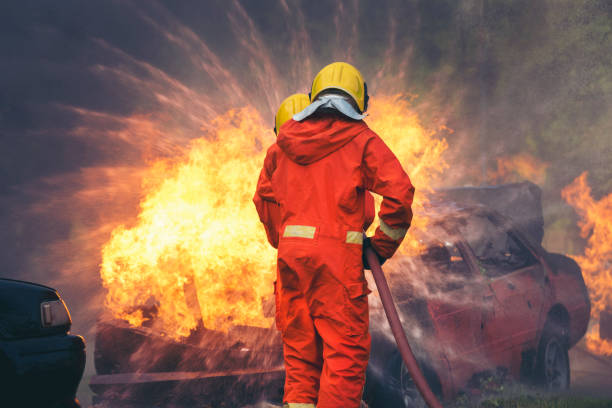 istock Firefighter fighting with flame using fire hose chemical water foam spray engine. Fireman wear hard hat, body safe suit uniform for protection. Rescue training in fire fighting extinguisher 1416790865