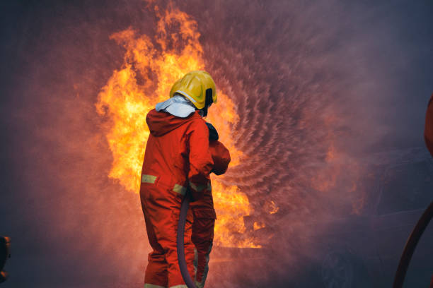 istock Firefighter Rescue training in fire fighting extinguisher. Firefighter fighting with flame using fire hose chemical water foam spray engine. Fireman wear hard hat, safety suit uniform for protection 1416790866