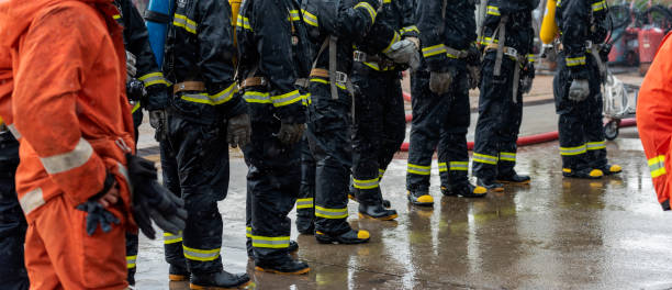 istock Firefighter Rescue team training in fire fighting extinguisher. Firefighter teamwork fighting with flame using fire hose chemical water foam spray engine. Fireman wear hard hat, safety suit uniform 1416790875