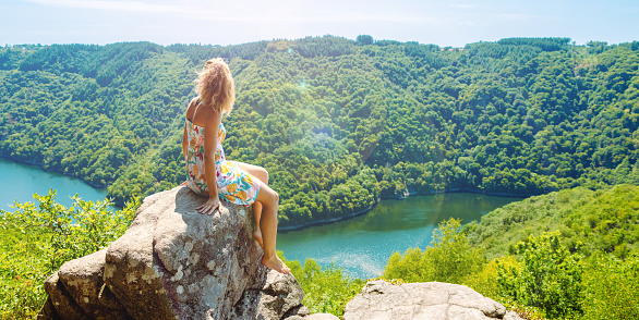 woman on a peak looking at mazing landscape view with forest and river ( Dordogne,  roc du busatier)
