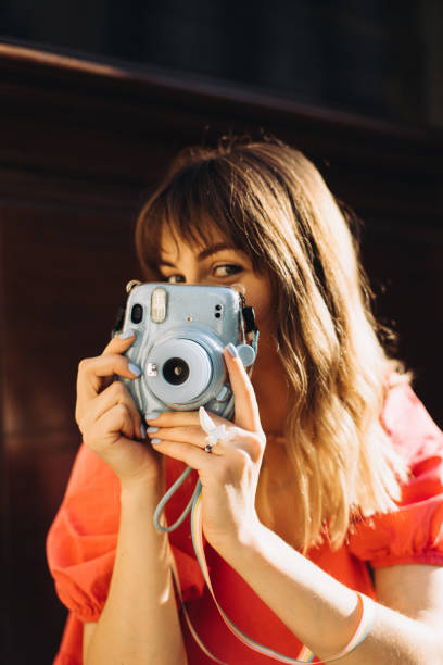 istock A beautiful woman take a shot on Instax camera 1416805528