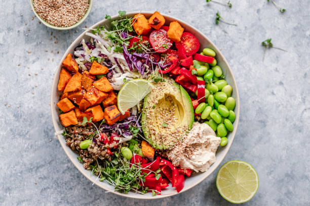 Colourful vegan bowl with quinoa and sweet potato Overhead view of a colourful vegan bowl with quinoa, sweet potato, avocado, hummus and variety of veggies salad stock pictures, royalty-free photos & images