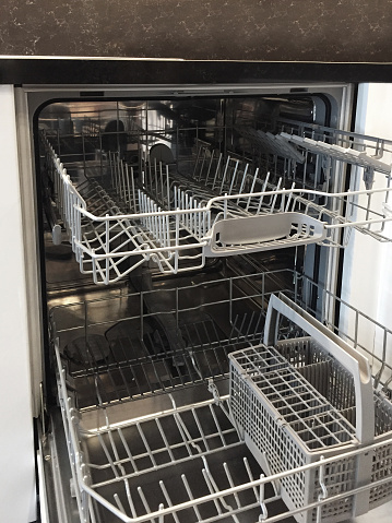 Open empty modern dishwasher in the kitchen
