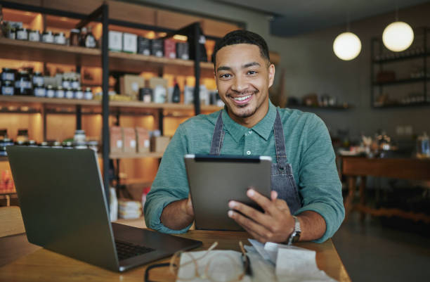 istock Deli manager smiling while using a tablet and laptop in his store 1416830712