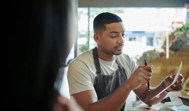 istock Young deli owner talking with his partner at a table in their shop 1416831271