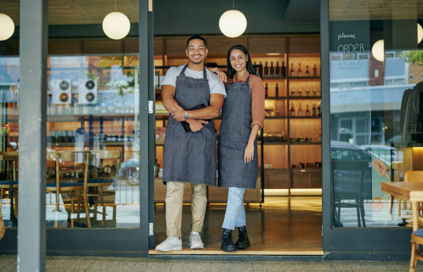 istock Young deli owners smiling while standing at their store entrance 1416833487
