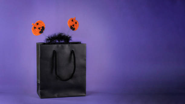 istock Black bag on dark purple background 1416833575