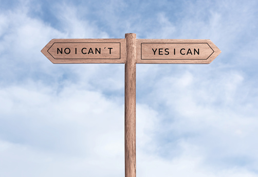Yes I can concept or No I can not. Signpost with two messages on opposite way and sky background