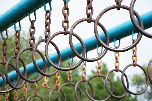 old rusty rings on a chain on a horizontal bar for gymnastics on the street, sports ground in Ukraine