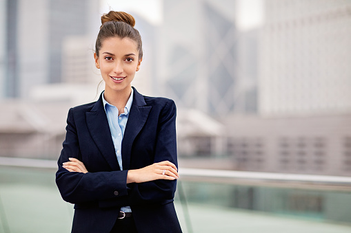 Portrait of young businesswoman at front of business district
