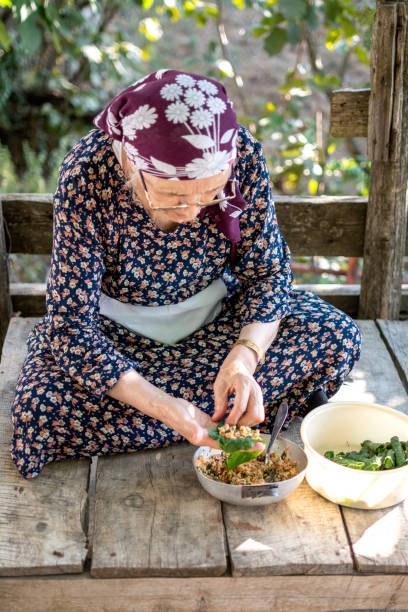 istock A senior woman is wrapping leaf wrapping, stuffed vine leaves with rice 1416851003
