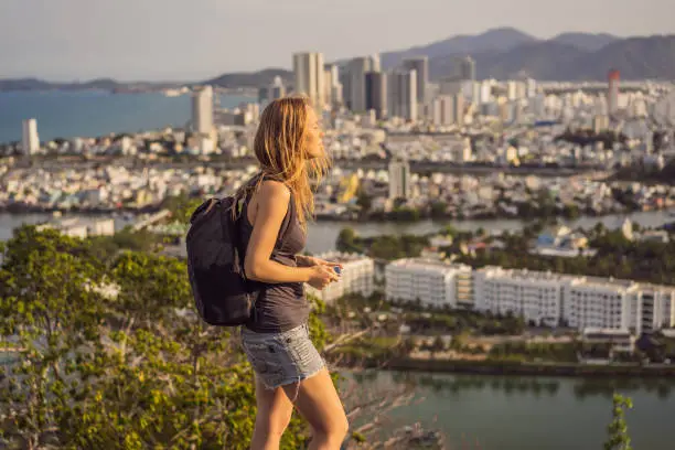 Photo of Woman tourist on the background of Nha Trang city. Travel to Vietnam Concept