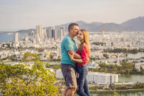 Photo of Happy couple tourists on the background of Nha Trang city. Travel to Vietnam Concept