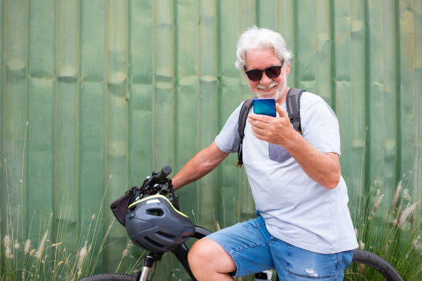 istock Attractive senior man with helmet and backpack using mobile phone while enjoying sport activity with electric bicycle in outdoors - sustainable mobility concept 1416861227