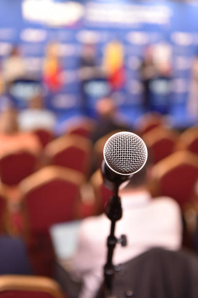 Detail shot with a microphone during a press conference. Audience in the background stock photo