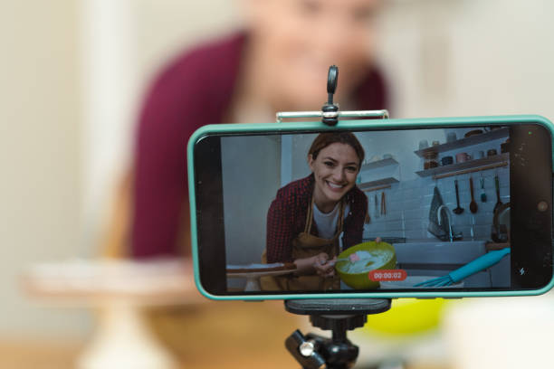 istock Happy, Young woman filming a baking tutorial with her smartphone 1416883556