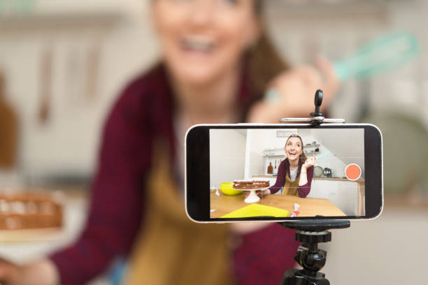 istock Phone filming while happy young woman making a cake 1416884102