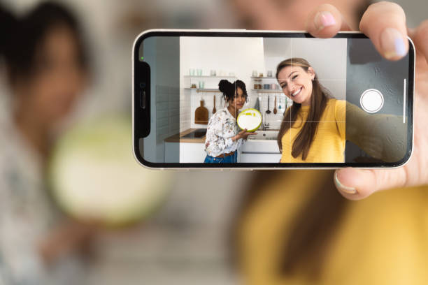istock Two best friends having fun and taking selfies while preparing a cake 1416884115