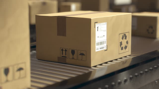 Packages moving through a postal distribution facility. Conceptual 3D computer animation of different packages on a conveyor belt in the warehouse.