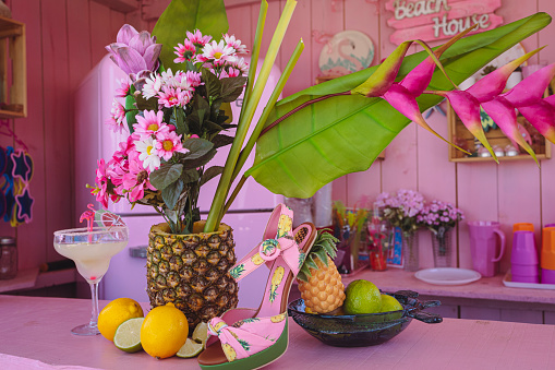Centerpiece with tropical fruits and flowers. Decoration for summer party. Cheerful decoration.