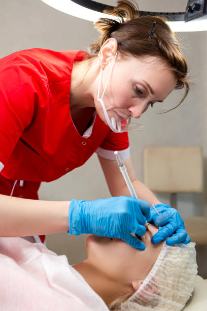 istock Microblading and Micropigmentation. Eyebrows Workflow in Beauty Salon While Caucasian Woman Having Eyebrows Drawn and Color Tinted With Semi-permanent Eyebrows Makeup. Focus on eyebrow 1416908982