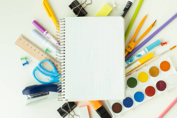 istock Blank notepad for free text next to the school supplies on the white background. Back to school concept on September day. Flat lay. Free space. 1416909127