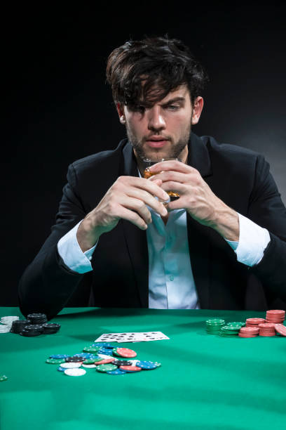 istock Frustrated Handsome Caucasian Brunet Young Pocker Player At Pocker Table With Chips And Cards While Drinking Alcohol. 1416911779