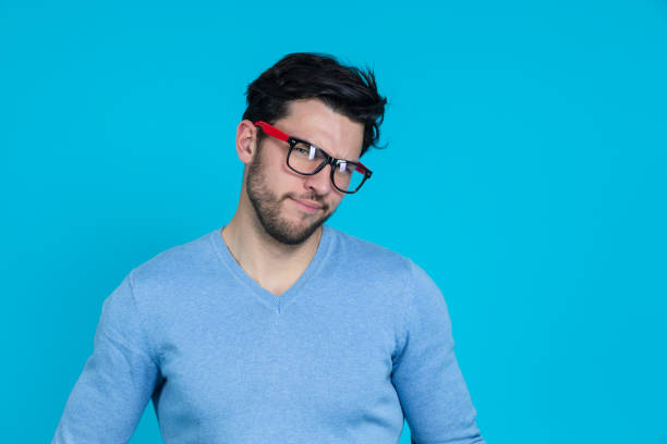 Extravagant Young Funny Handsome Caucasian Man in Glasses With Folded Hands Having Fun Against Seamless Blue Background. Horizontal Image