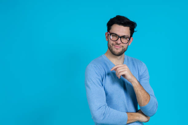 istock Young Handsome Caucasian Man in Glasses With Folded Hands Looking Straight And Smiling Against Seamless Blue Background. 1416912409