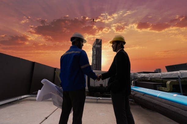 manager visit engineer working on the rooftop near pipe rack to inspection the progress by drone fly - civil building imagens e fotografias de stock