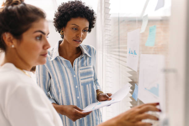 istock Two young businesswomen analysing some documents during a meeting 1416913715