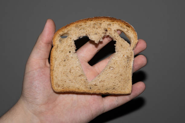 istock Rye bread bread slice with heart shaped hole on a hand 1416914130