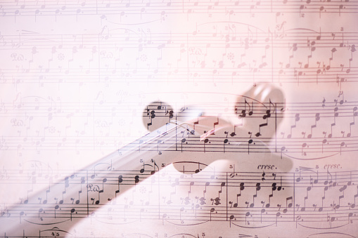 A multiple exposure of a sheet of piano music and the close up of a violin (public domain score sheet)