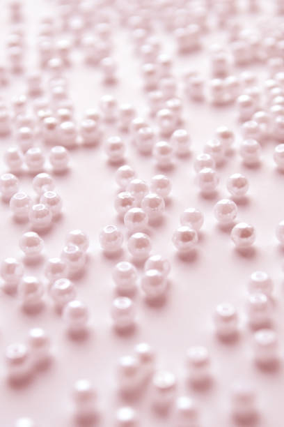Pink beads on a pink background. Pink beads background. Crafts, weaving from beads