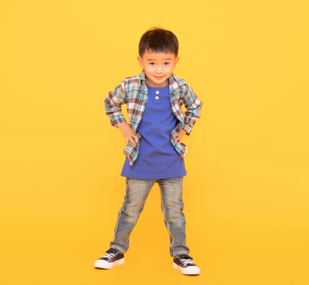 istock happy asian kid standing  over yellow background 1416925968