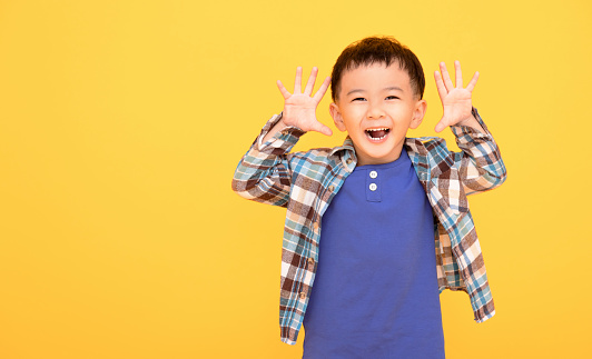 excited asian boy  gesturing actively with both hands